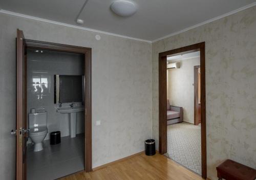 an empty bathroom with a toilet and a sink at PARK HOTEL Uralsk in Oral