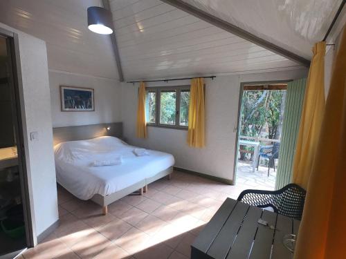 - une chambre avec un lit, une table et une fenêtre dans l'établissement Kallisterra, à Sainte-Lucie de Porto-Vecchio