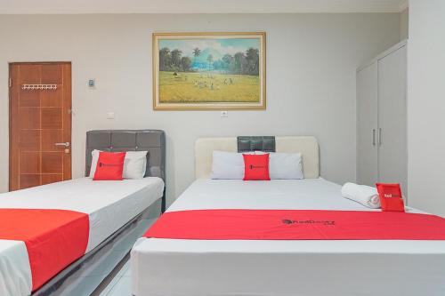 two beds sitting next to each other in a room at RedDoorz Plus at Bukit Cinta Street Balikpapan in Klandasan Kecil