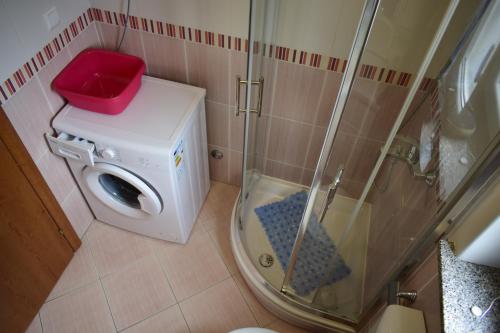 eine Duschkabine in einem Badezimmer mit einer roten Box darauf in der Unterkunft Apartment Eve in Klimno