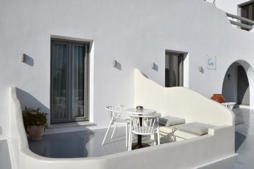 Habitación blanca con mesa y sillas en Crystal Mare Suites, en Naxos Chora