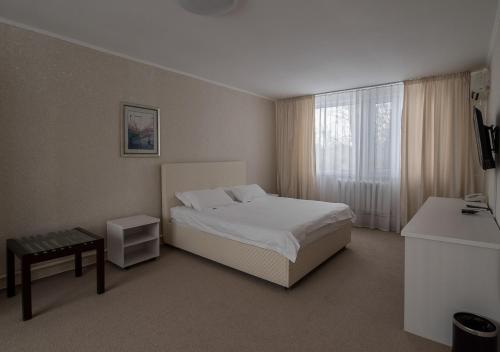 a bedroom with a white bed and a window at PARK HOTEL Uralsk in Uralsk