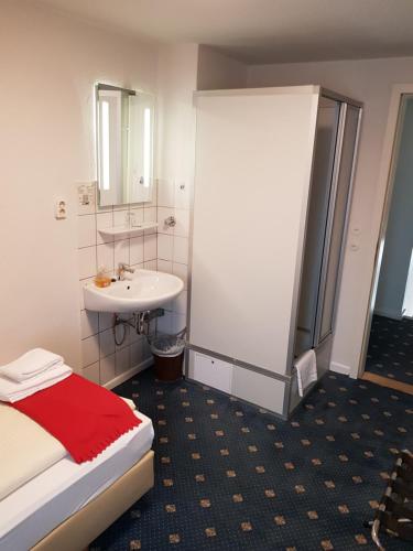 a bathroom with a bed and a sink and a shower at Hotel Flora in Hannover