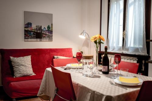 PignolaにあるLe Conifereのワイングラスと赤いソファー付きのテーブル