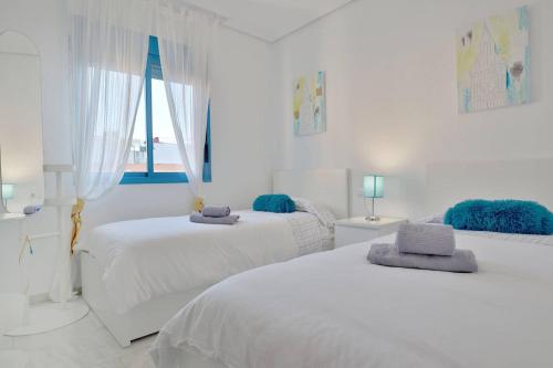two white beds in a white room with a window at CONFORT CORDOBA CENTRO II in Córdoba