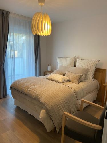 - une chambre avec un grand lit et une grande fenêtre dans l'établissement DOMITYS - Les Papillons d'Azur, à Saint-Quentin