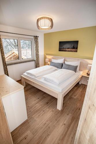 a bedroom with a large white bed in a room at Ferienwohnungen "Zur Wally" in Garmisch-Partenkirchen