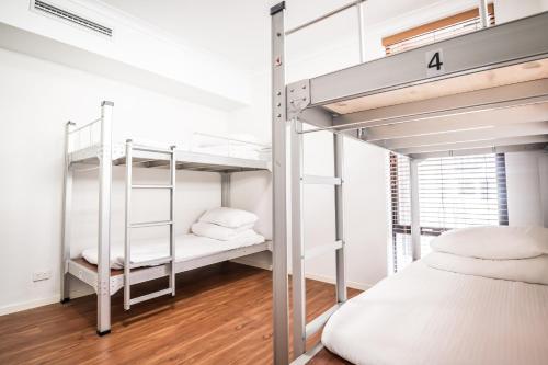 um quarto com 2 beliches e uma cama em Downtown Backpackers Hostel Perth - note - Valid Passport required for check in em Perth