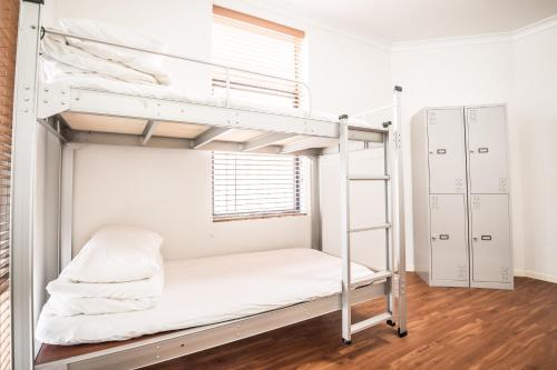 a bunk bed in a room with a ladder at Downtown Backpackers Hostel Perth - note - Valid Passport required for check in in Perth