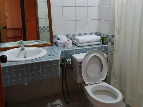 a bathroom with a toilet and a sink at Seri Bulan Condo in Port Dickson