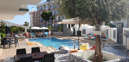 ein Pool mit Tischen und Stühlen und ein Hotel in der Unterkunft Esperanza Hotel in Antalya