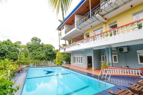 una imagen de una piscina frente a una casa en Blue Haven Guest House, en Kandy