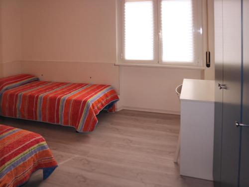リニャーノ・サッビアドーロにあるStiriaのベッド2台、冷蔵庫が備わる小さな客室です。