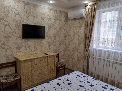 アナパにあるHoliday Home on Krasnozelenykhのベッドルーム1室(壁にテレビ付)、ベッド1台が備わります。