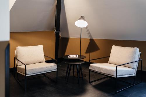 duas cadeiras e uma mesa e um candeeiro num quarto em The Hunfeld em Utrecht