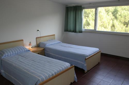 - 2 lits dans une chambre d'hôtel avec fenêtre dans l'établissement Pinetina Beach, à Silvi Marina