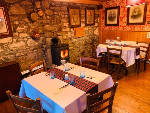 
a restaurant with tables and chairs and a large window at Aultguish Inn in Garve

