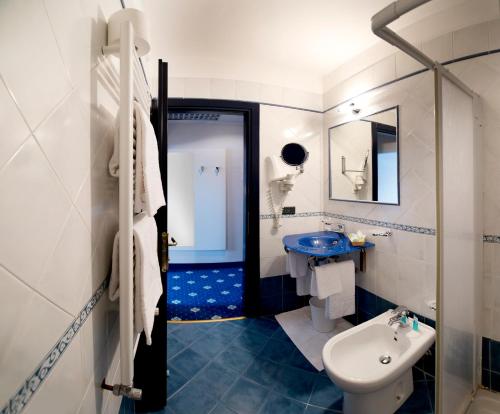 a blue and white bathroom with a sink and a toilet at Hotel Estense in Modena