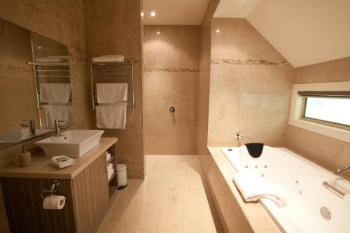 a bathroom with a tub and a sink at Wild Cattle Creek Estate in Wandin Yallock