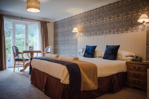 a hotel room with a large bed and a table at Flackley Ash Country House Hotel in Rye