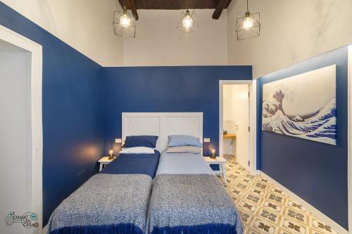 two beds in a room with blue walls at Le Chiavi di Casa in Naples