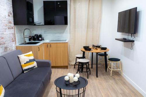 un salon avec un canapé et une table et une cuisine dans l'établissement Rent a Room - Cosy 1BDR, à Paris