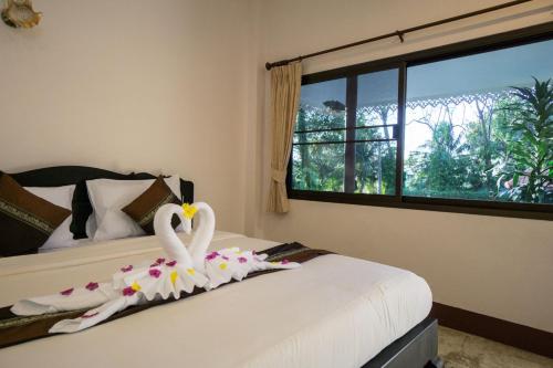 two swans are sitting on a bed in a bedroom at Chang Cliff Resort in Ko Chang