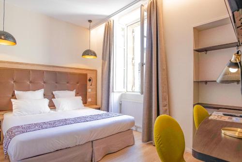 Hôtel Montaigne tesisinde bir odada yatak veya yataklar
