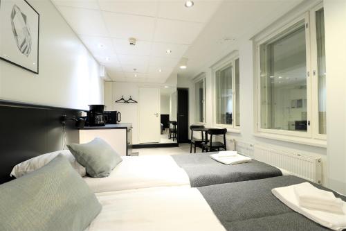 タンペレにあるフォレノム アパートホテル タンペレのベッドルーム1室(ベッド2台付)、リビングルームが備わります。