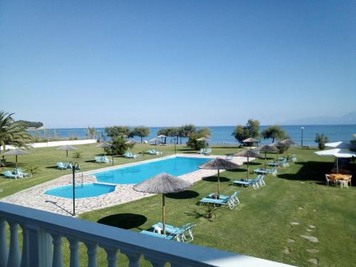 a view of a swimming pool with chairs and umbrellas at S&C Kosmos Beach Resort in Roda