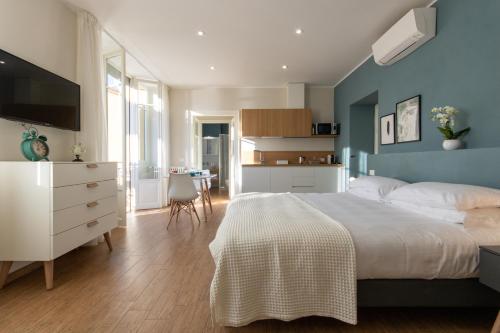 een slaapkamer met een wit bed en een blauwe muur bij Aqualago casa vacanze apartment D in Verbania