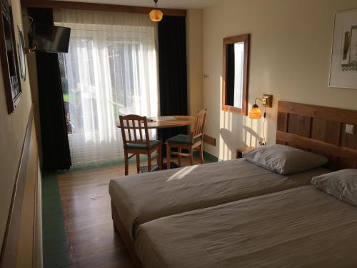 Schlafzimmer mit einem Bett, einem Tisch und Stühlen in der Unterkunft Carels Kamers Texel in De Koog