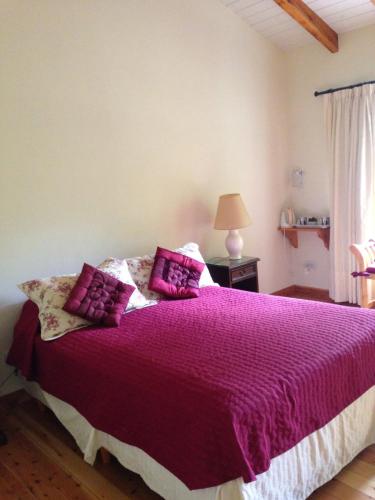 Un dormitorio con una cama grande con sábanas y almohadas púrpuras. en Los Abetos B&B 2 en El Bolsón