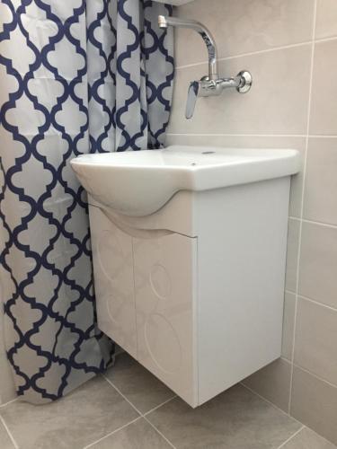a bathroom with a sink and a shower curtain at Villa Draganovi in Kamen Bryag