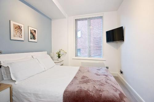 a bedroom with a bed and a tv on the wall at Mulberry Flat 4 - Two bedroom 2nd floor by City Living London in London