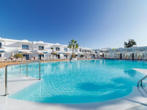 a large swimming pool in the middle of a resort at Arena Beach in Corralejo