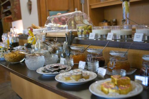 a buffet line with plates of food on a counter at Hotel Garni Lehrertal in Ulm