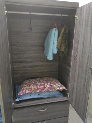 a wooden cabinet with a bed in a closet at Bonda Guesthouse I in Paka