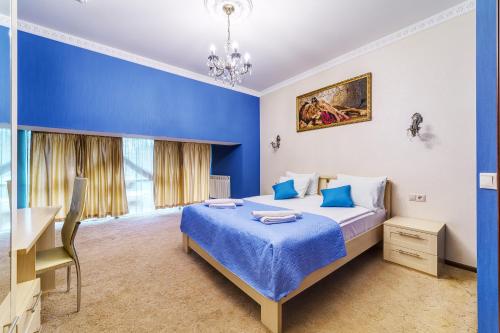 a blue bedroom with a bed and a desk at Hotel Elite in Moscow