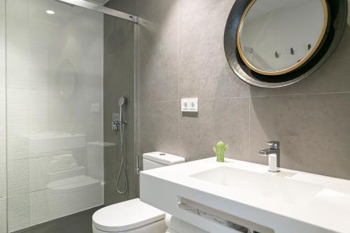 a bathroom with a white sink and a mirror at Teatro Romano 7 & 8 in Málaga
