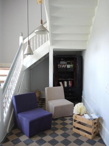 a living room with a couch and a chair and stairs at Netts Landhaus in Neustadt an der Weinstraße