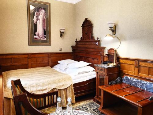a bedroom with a bed and a table and a desk at Pałac Czarny Las (50 km od Katowic) in Woźniki