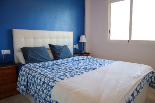 sypialnia z dużym łóżkiem i niebieską ścianą w obiekcie 2 bed penthouse, Bolnuevo w mieście Bolnuevo