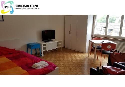 a room with a bed and a tv and a table at HSH Breitenrain - Serviced Apartment - Bern City by HSH Hotel Serviced Home in Bern