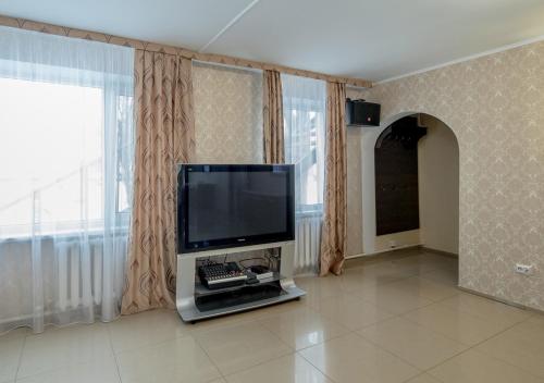 a living room with a flat screen tv and a keyboard at PARK HOTEL Uralsk in Uralsk