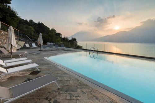 ベッラーノにあるMagic lake view with beautiful pool area (camelia)の水辺の景色を望むプール(椅子付)