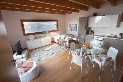 cocina y sala de estar con mesa y sillas. en Magic lake view with beautiful pool area (camelia), en Bellano