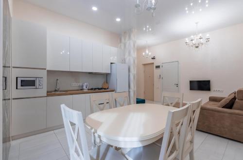 a kitchen and living room with a white table and chairs at SWEET HOME 7 at Freedom Square in Tbilisi City