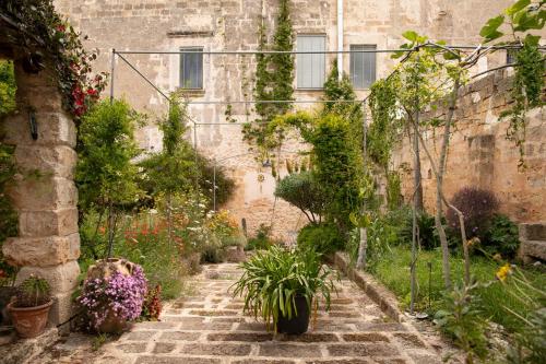 einen Garten in einem alten Gebäude mit Blumen und Pflanzen in der Unterkunft Castle XVIII near sea in Gagliano del Capo