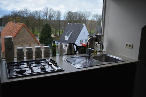 a kitchen counter with a stove and a sink at Maison Anna Clara in Nieuwpoort